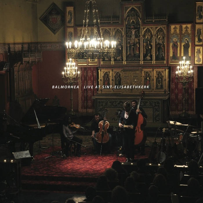 Album cover of Balmorhea Live at Sint-Elisabethkerk. 4 classical musicians performing beneath an antique,brightly lit chandelier